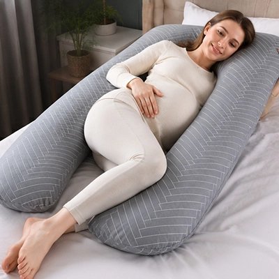 Coussin de grossesse gris rayé entoure future maman qui se repose