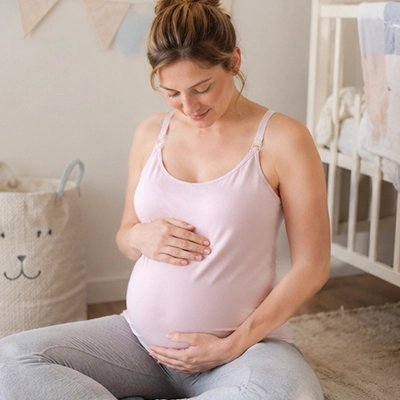 Débardeur allaitement blanc porté par future maman assise par terre